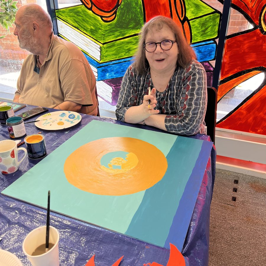 Image shows artist from a well being group and their work in progress