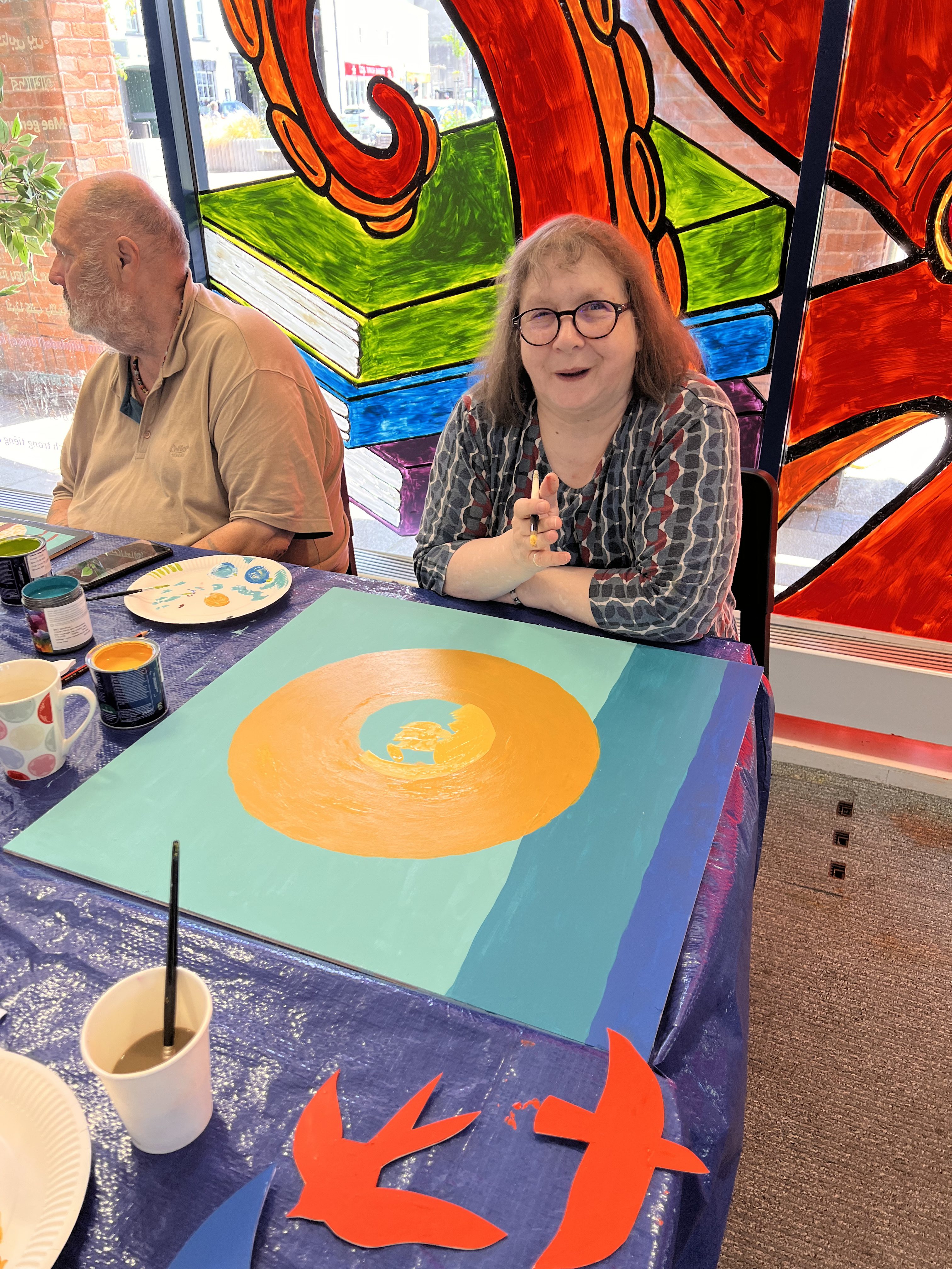 Image shows artist from a well being group and their work in progress