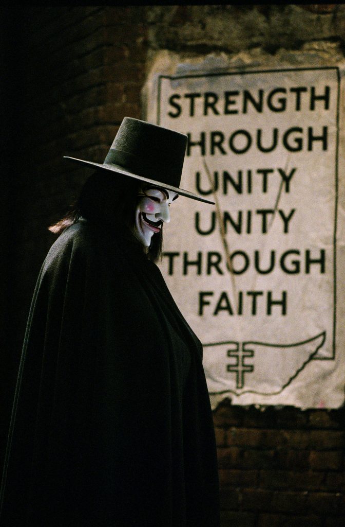 Still from the film V for Vendetta. A masked figure in black