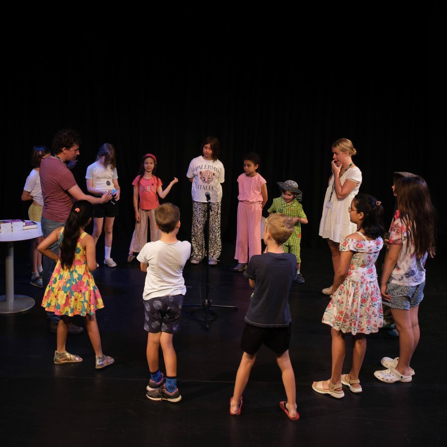 A group of young people stand in a circle with two older people