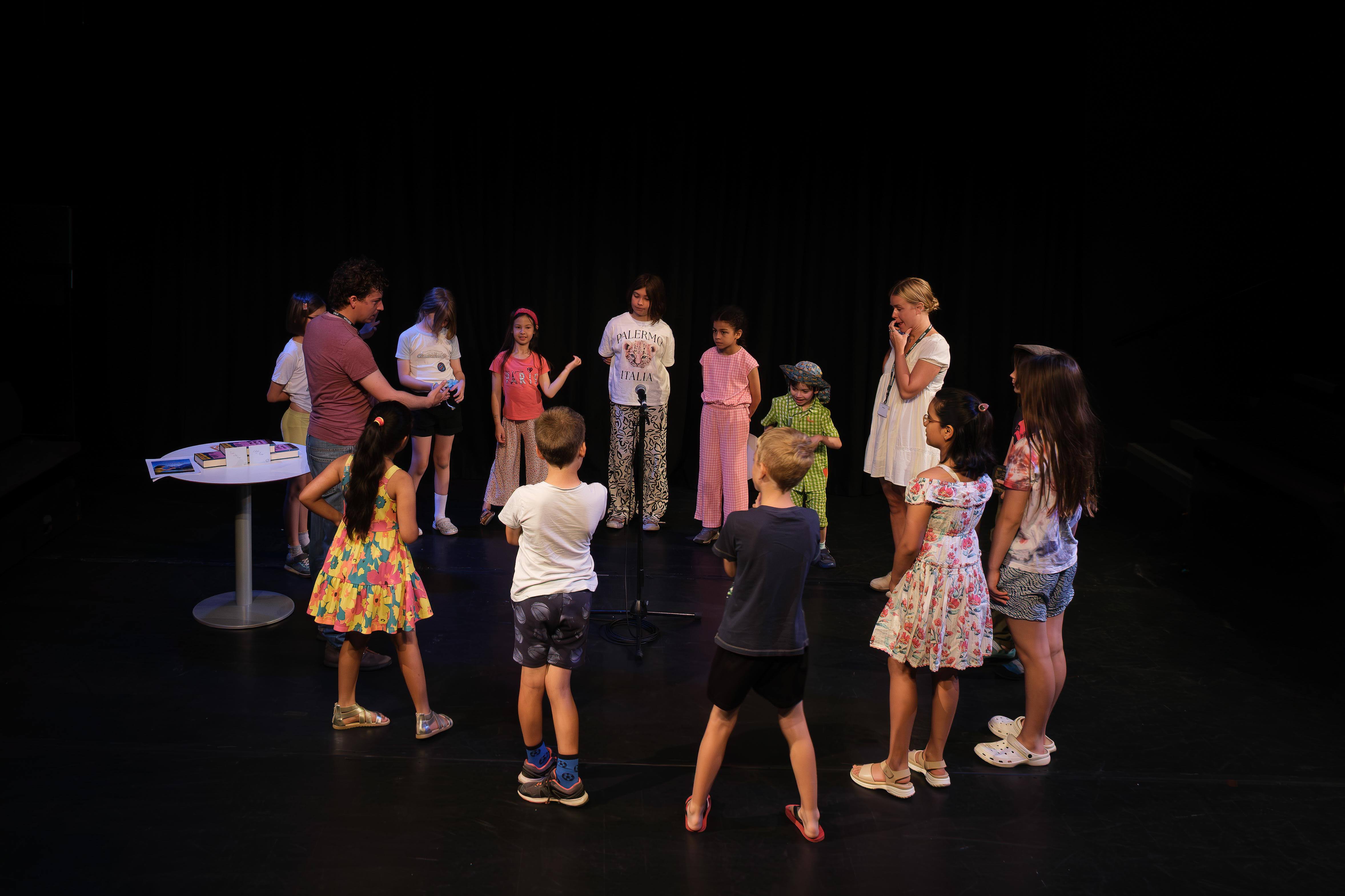 A group of young people stand in a circle with two older people