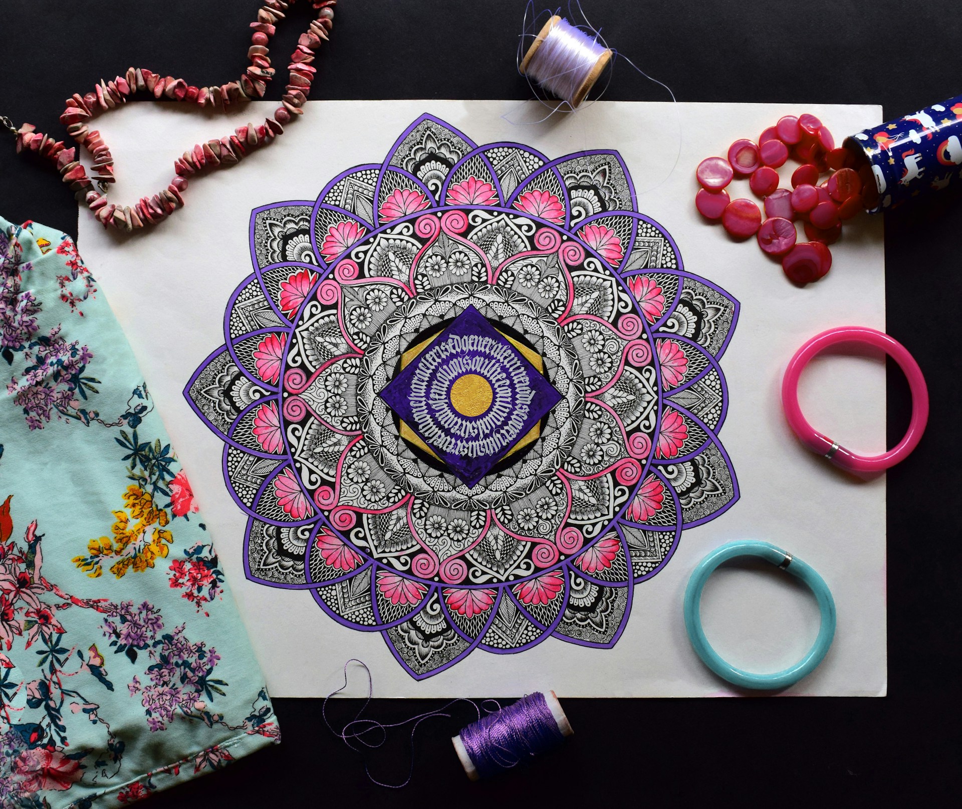 An Indian mandala surrounded by textiles and beads