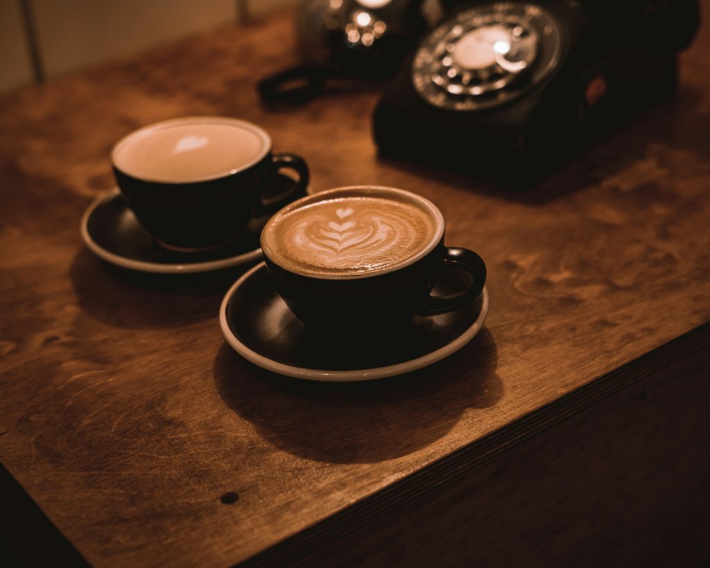 Cups of coffee with patterns on the foam
