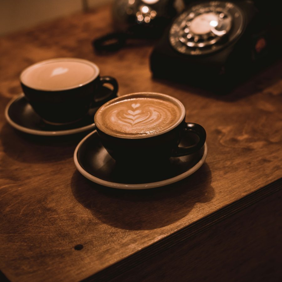 Cups of coffee with patterns on the foam